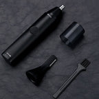 Black  ClipCrazie Nasal Hair Trimmer  with attachments on a dark textured surface