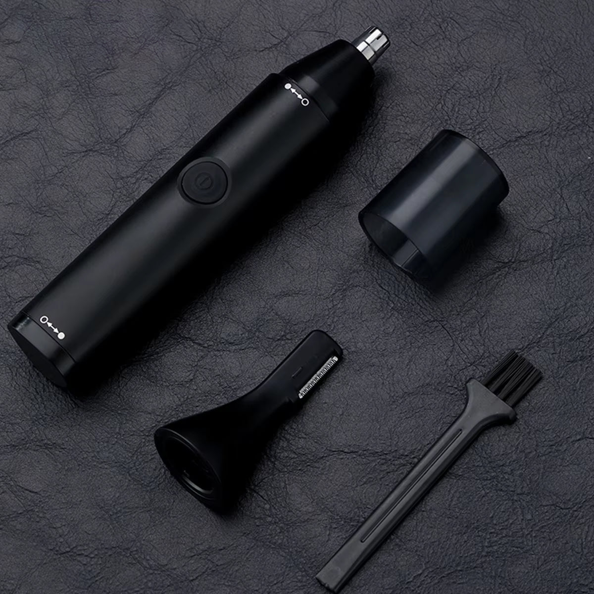 Black  ClipCrazie Nasal Hair Trimmer  with attachments on a dark textured surface