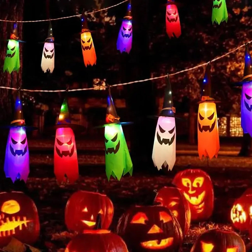 HexWitchi Jack O Lantern with colorful ghost shapes and carved pumpkins in a dark outdoor setting.