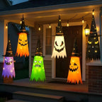 HexWitchi Jack O Lantern on a house porch with glowing lights and colorful faces.