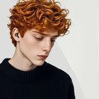 Person with red hair wearing a HuziNite Earplugs  against a light gray background