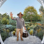 Man in a garden setting with tools, waving at the  PurePeeki Camera Doorbell 