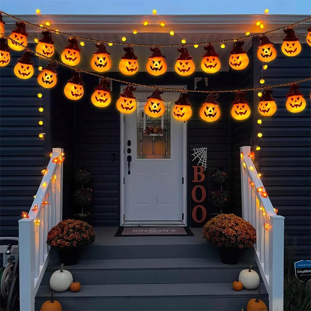 A front porch decorated for Halloween with multiple strings of Sunpikoex Solar Pumpkin Lights  draped across the entryway, white railings with warm lights, pumpkins, mums, and a vertical BOO sign on the door.
