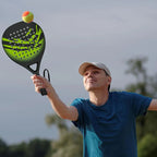Man holding a pickleball Tennisixo Padel Racket with a pickleball in the air, outdoors.